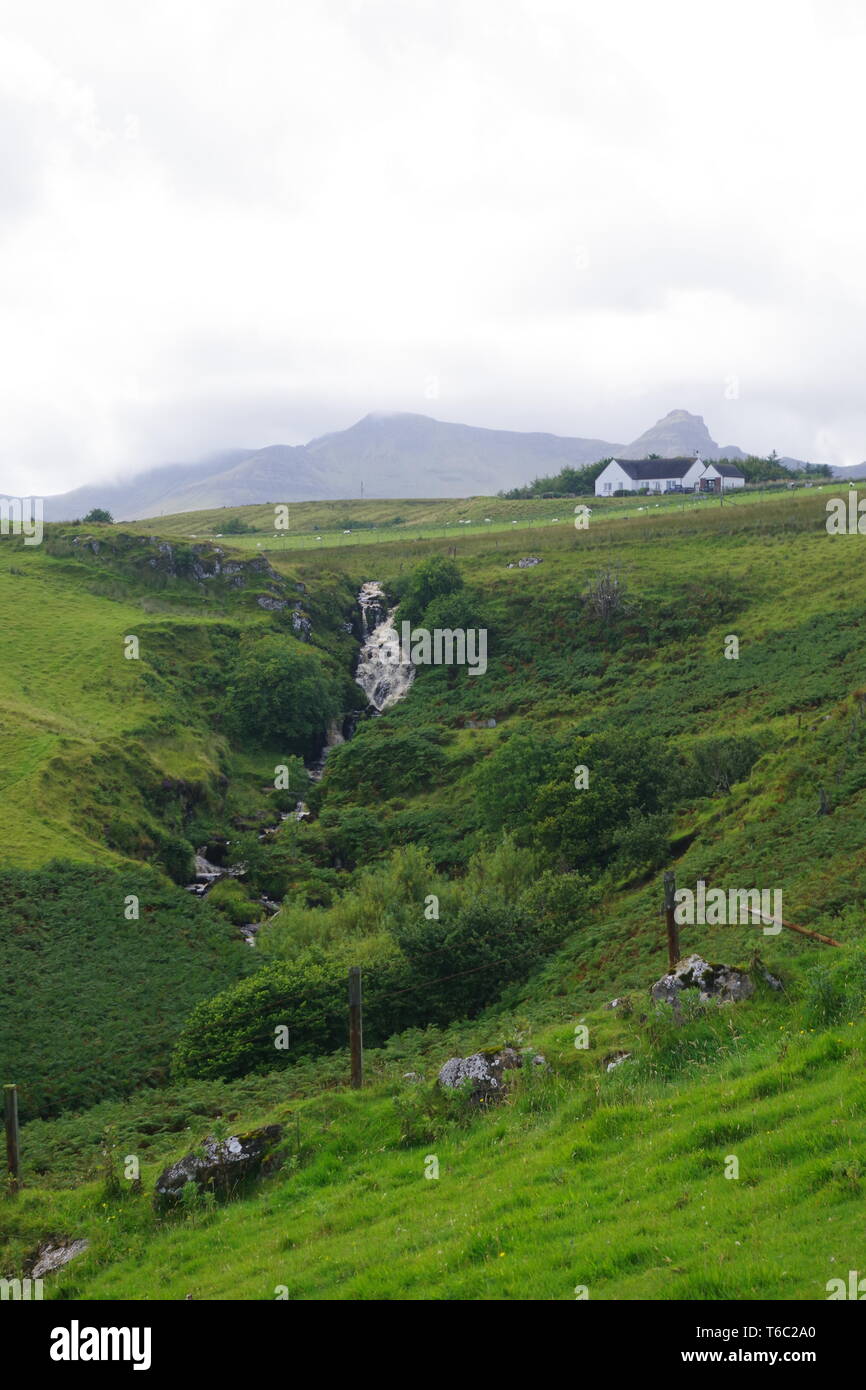Lonfearn Brennen durch pulsierende grüne Landschaft unter niedrigen Cloud mit Berge bei Brüder Point (Rubha nam Brathairean) Isle of Skye, Schottland, Großbritannien. Stockfoto