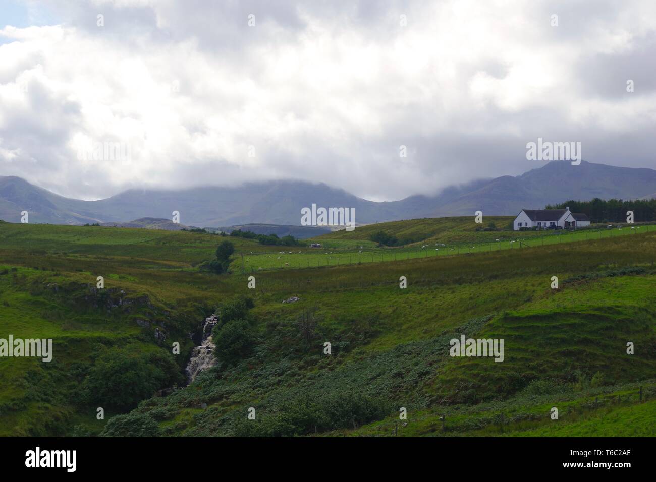 Lonfearn Brennen durch pulsierende grüne Landschaft unter niedrigen Cloud mit Berge bei Brüder Point (Rubha nam Brathairean) Isle of Skye, Schottland, Großbritannien. Stockfoto