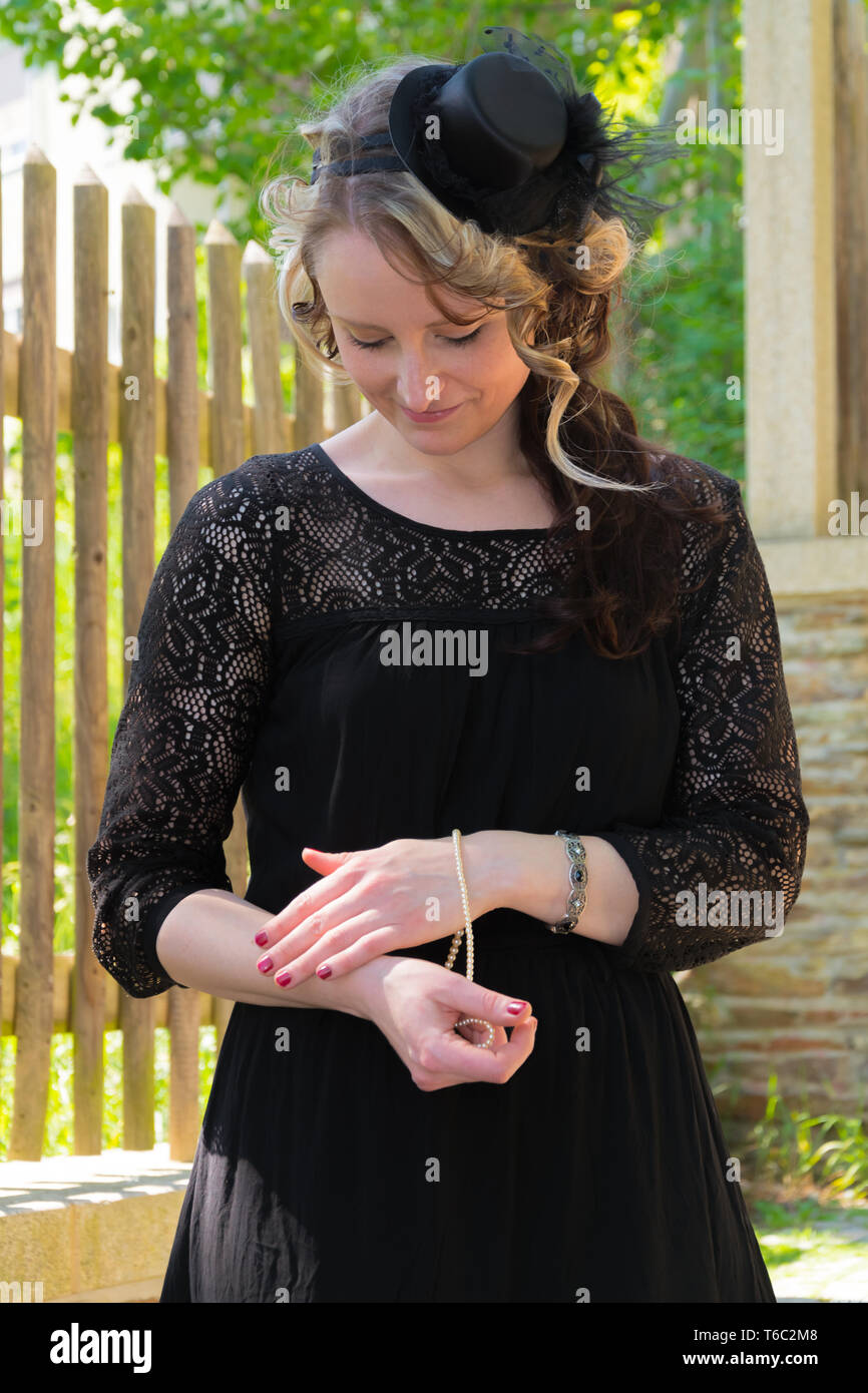 Woman in Black Dress, die versuchen, auf einem Armband Stockfoto