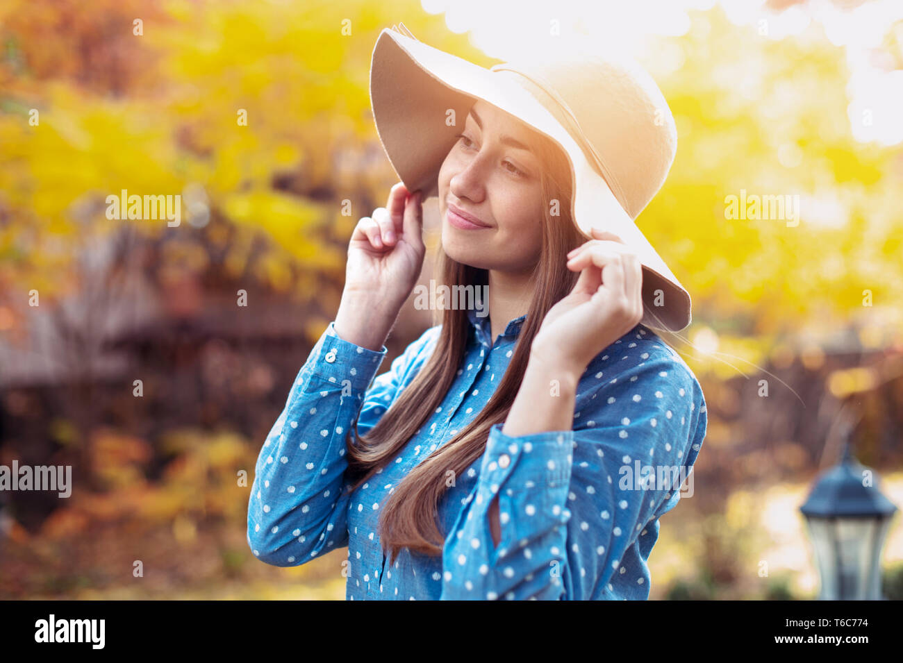 Schöne junge Frau Wandern im Herbst Park. Wunderschöne junge Frau, die im Herbst mit großen Hut, lächelnd und Natur genießen Stockfoto