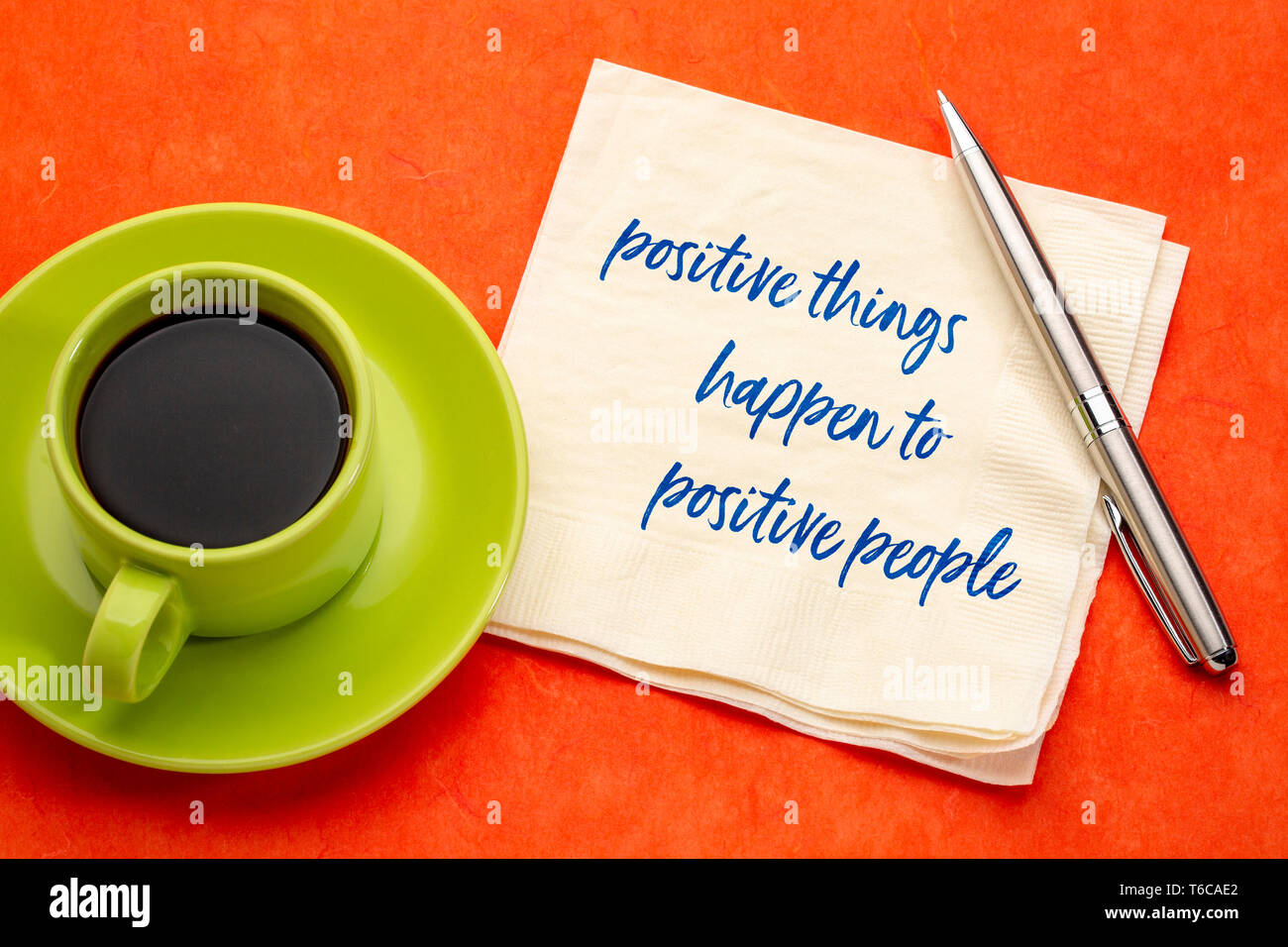 Positive Dinge geschehen mit positiven Menschen - Handschrift auf eine Serviette mit einer Tasse Kaffee, Gesetz der Anziehung Konzept Stockfoto