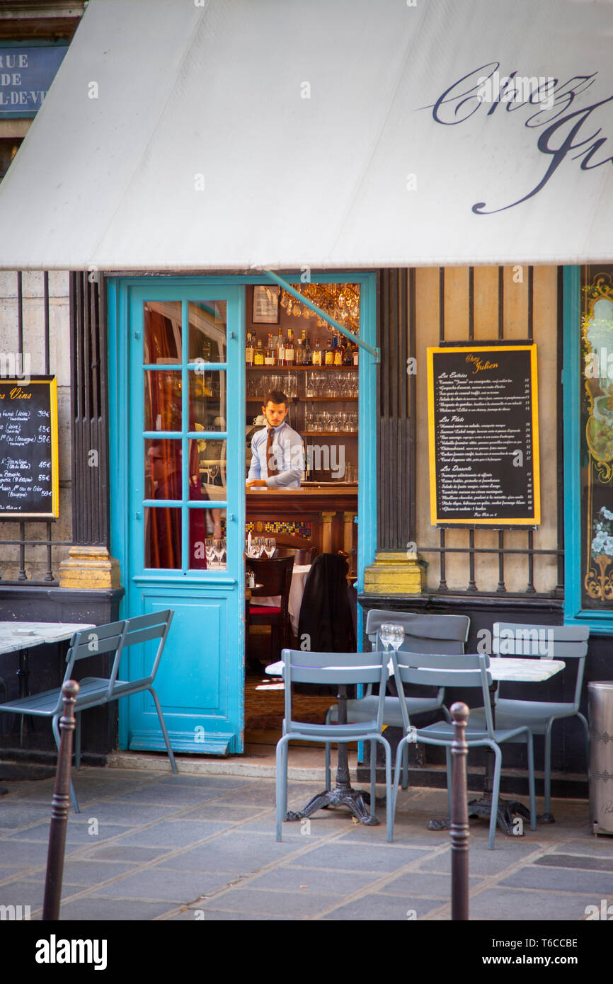Vordere Türen und Sitzgelegenheiten im Freien bei Chez Julien - ein Cafe im 4. Arrondissemont, Paris, Frankreich Stockfoto