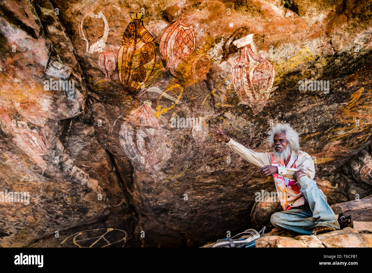 Einheimischer Guide erklärt Aborigine Rock Kunst in Long Tom Träumen, Gunbalanya, Australien Stockfoto