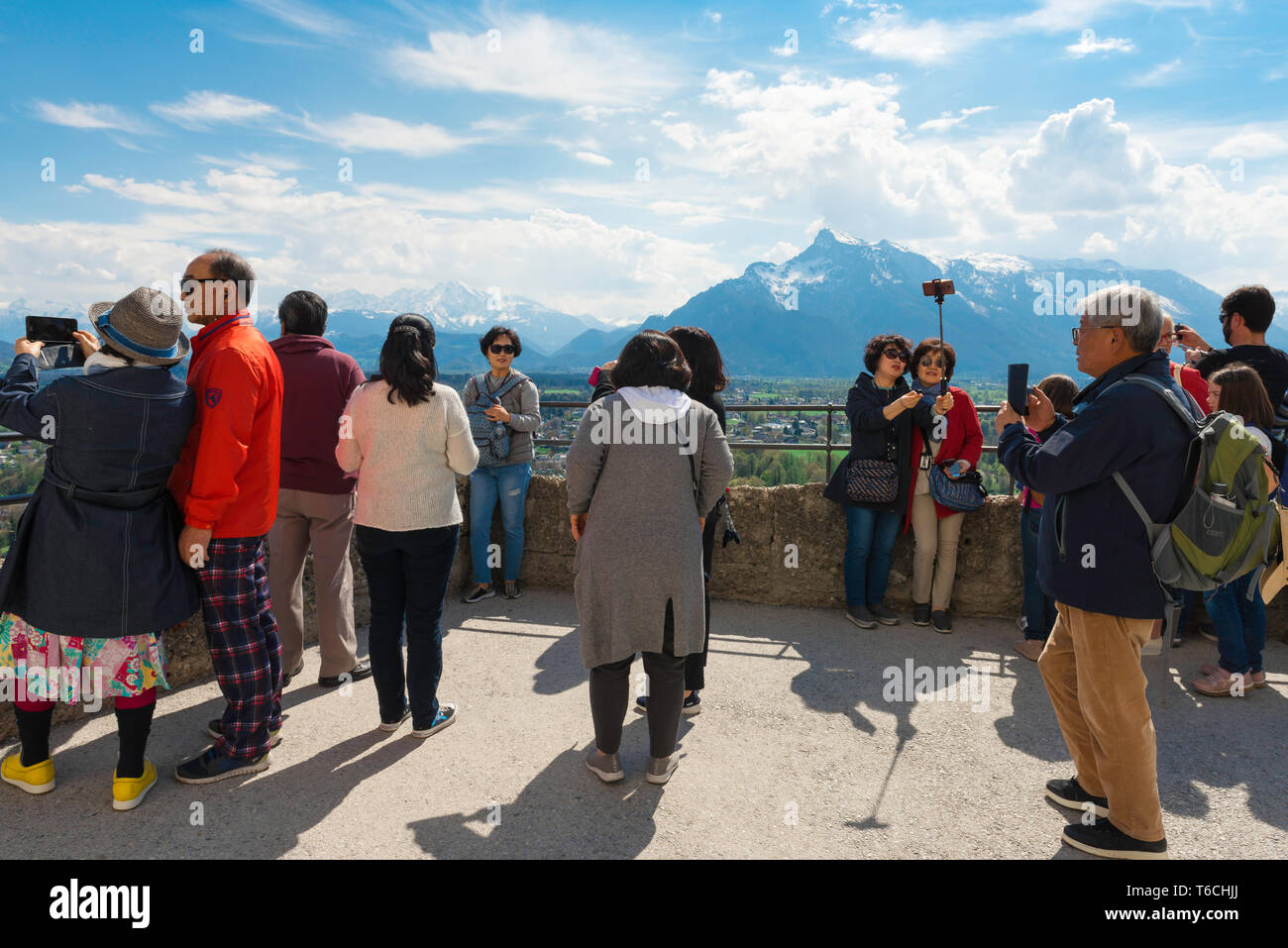 Chinesische Touristen in Europa, einer Chinesischen Reisegruppe die alpine Landschaft aus dem Salzburger Schloss Aussichtsterrasse, Österreich. Stockfoto