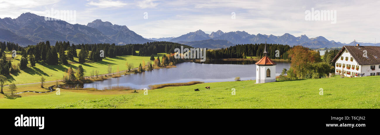 Ländliche panorama Szene mit Bergen, Bauernhof Haus und Kapelle in Bayern Stockfoto