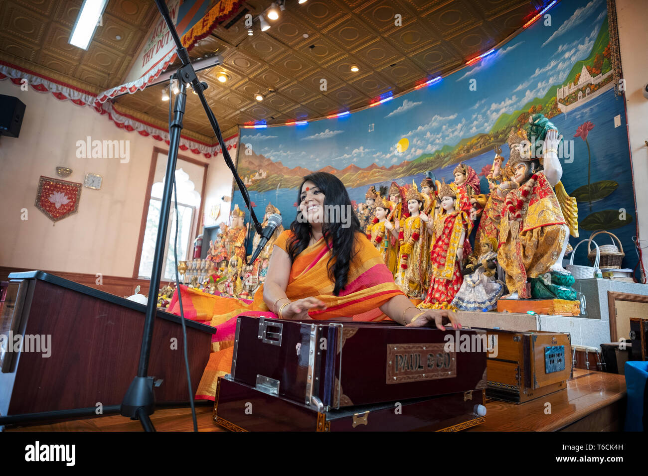 PANDITA. Eine weibliche Hindu Priesterin singt ein Gebet während der Wiedergabe eines Harmonium an einem Tempel in Jamaica, Queens, New York City. Stockfoto