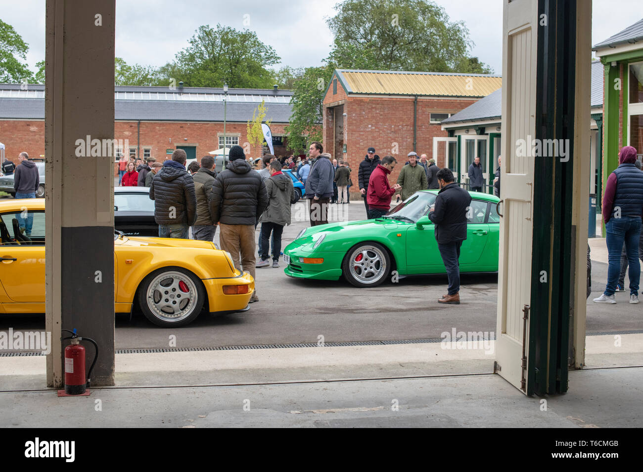 1995 Porsche Carrera RS und 1994 Porsche Carrera Autos vor einer Garage im Bicester Heritage Center. Bicester, Oxfordshire, England Stockfoto