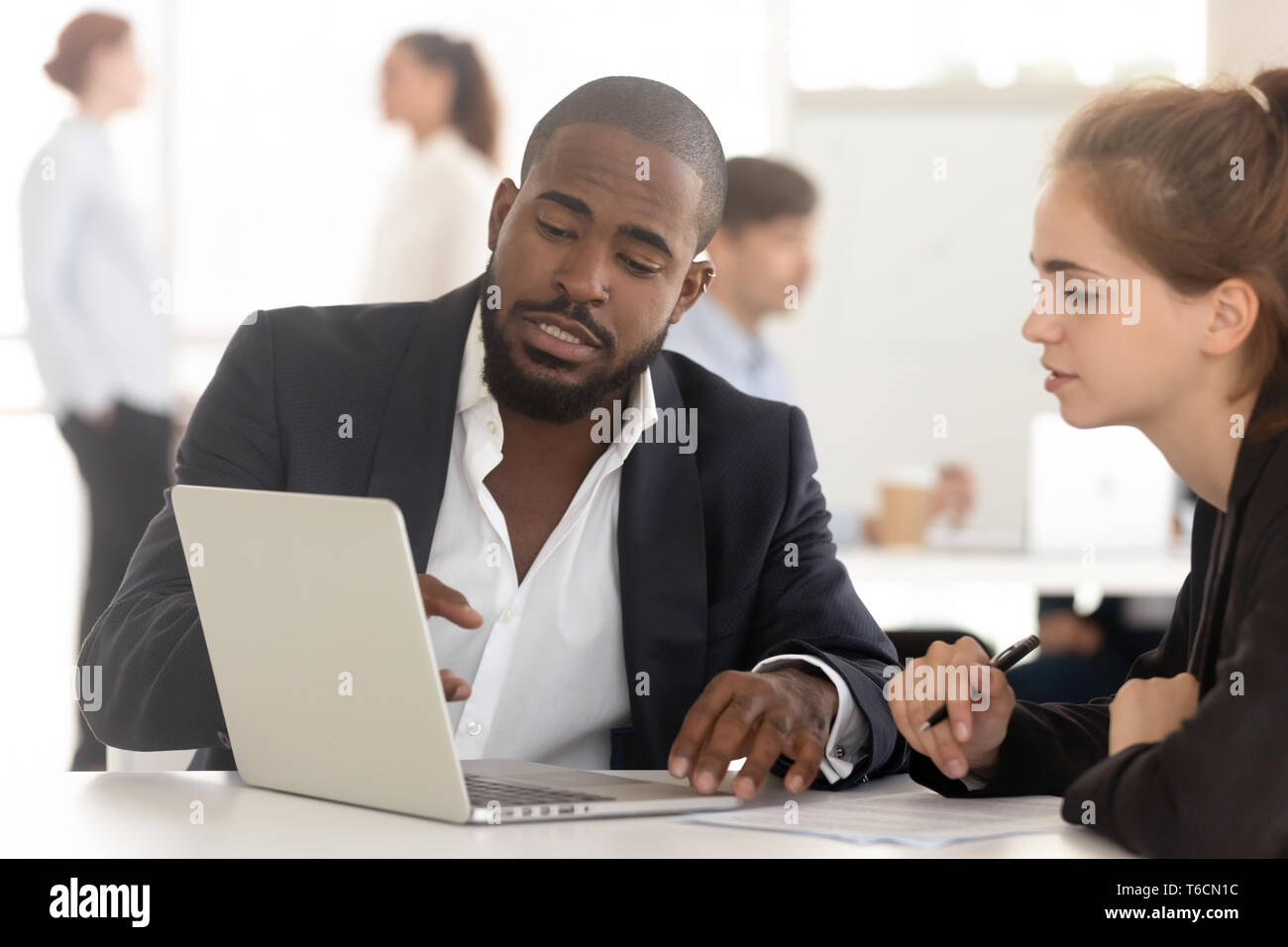 Schwarz Maklerversicherer Consulting arbeiten mit Kunden am Laptop suchen Stockfoto