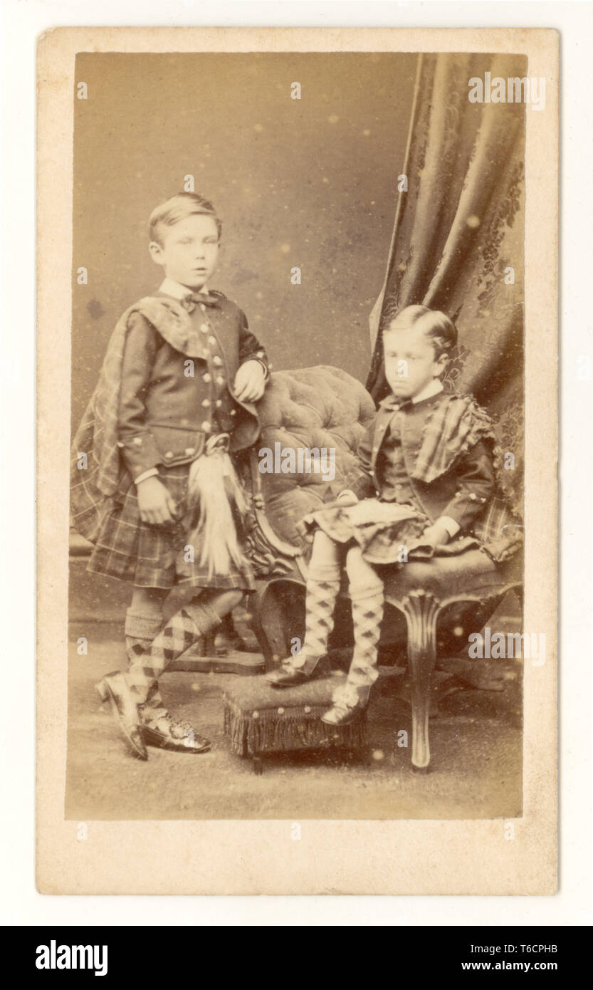 Ursprüngliche frühe verblasste Carte de Visite (CDV) viktorianische, junge Jungen in modischen schottischen Highland-Kilts, mit passenden karierten Schals mit Jacken und Socken, aus Clarks Studio, Brighton, U.K., um 1860 Stockfoto