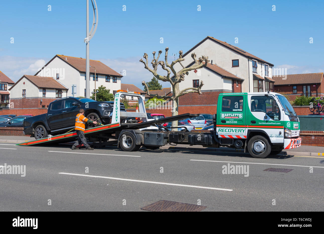 Bartletts Pannenhilfe Fahrzeug am Straßenrand, ein Auto auf einem Anhänger in Großbritannien. Stockfoto