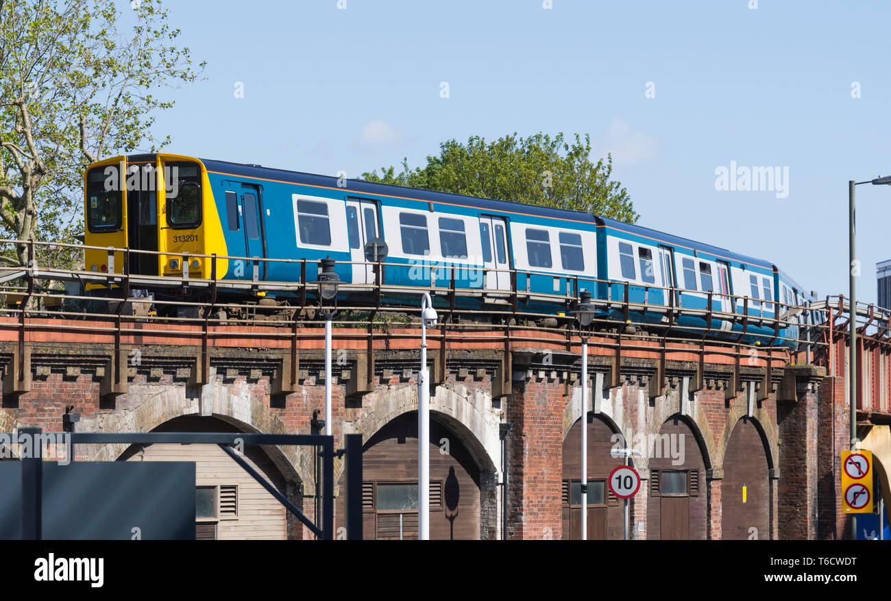 Klasse 313 EWU-Lokomotive (313 201) im Original British Rail Blau & Grau Erbe Livree in Portsmouth, Hampshire, Großbritannien überholt. Zug auf einer Brücke. Stockfoto