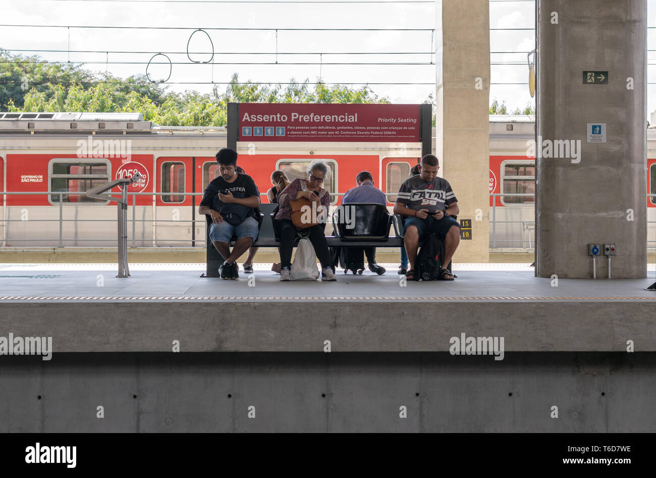 Menschen großen Altersunterschied warten auf die U-Bahn auf eine bevorzugte Sitz während der Verwendung von Smartphones Handys Stockfoto