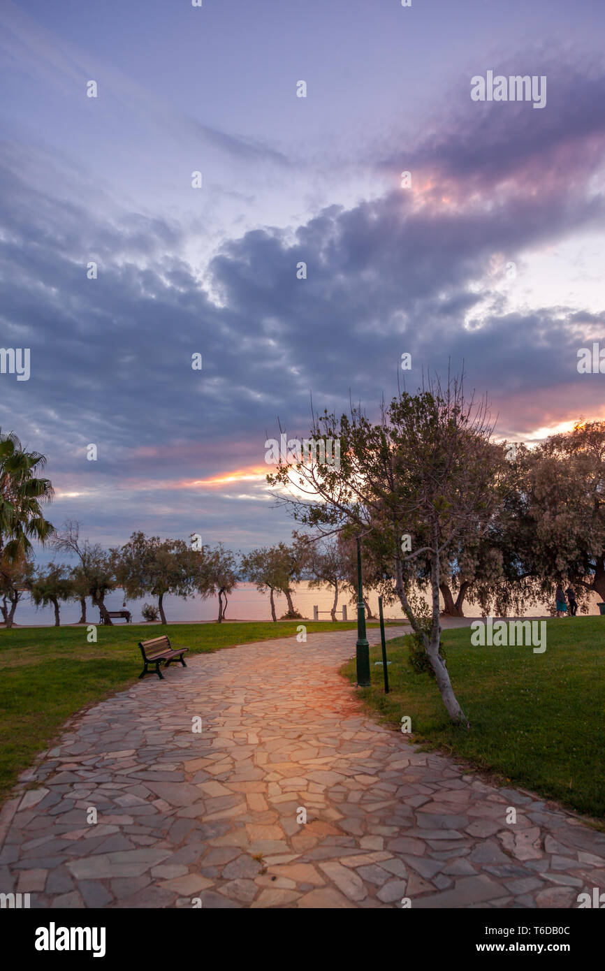 Steinboden in einem öffentlichen Park bei Sonnenuntergang mit schwere, dunkle Wolken. In Athen, Griechenland Stockfoto