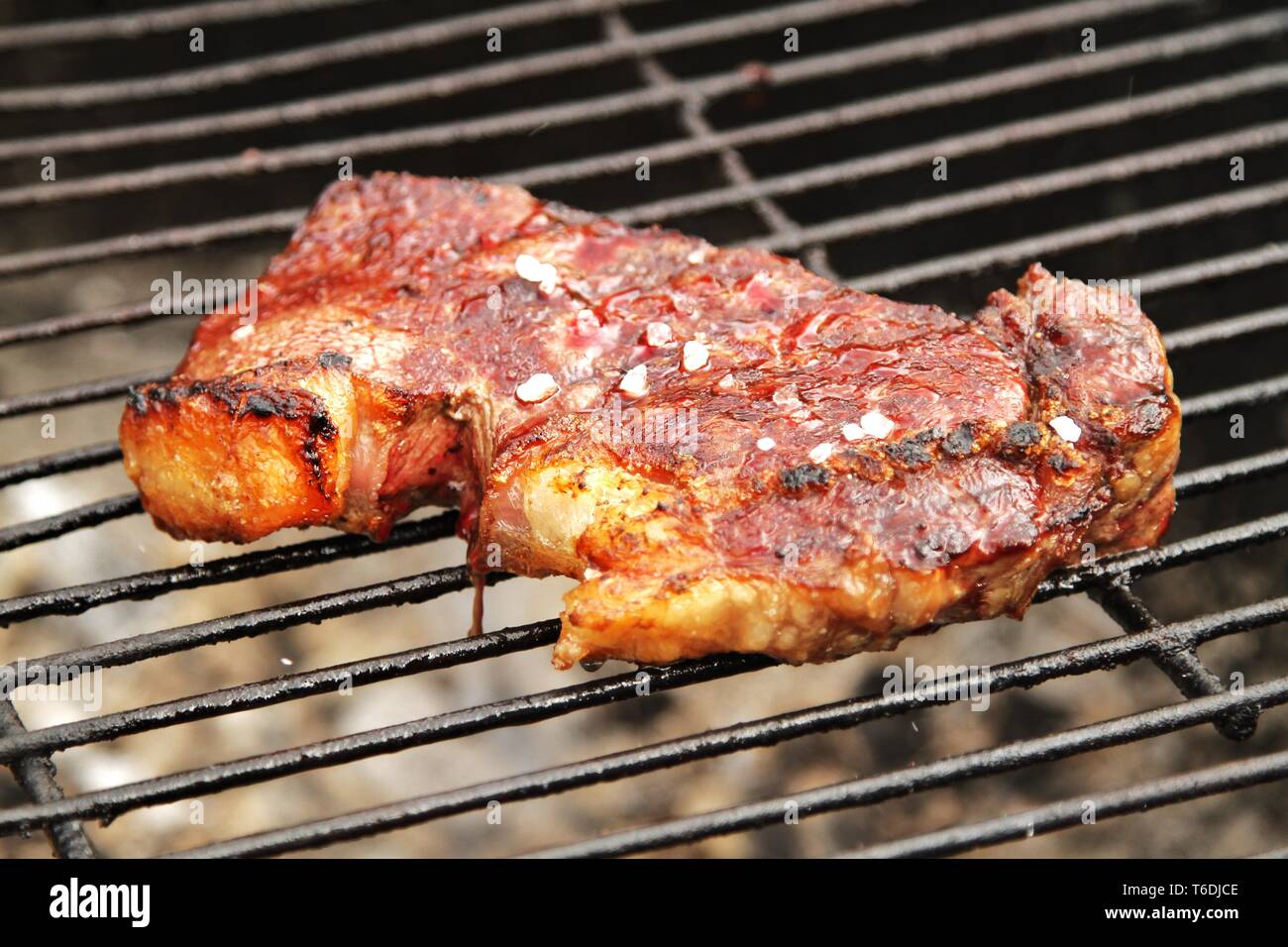Saftiges Steak mit Meersalz auf dem Grill Stockfoto