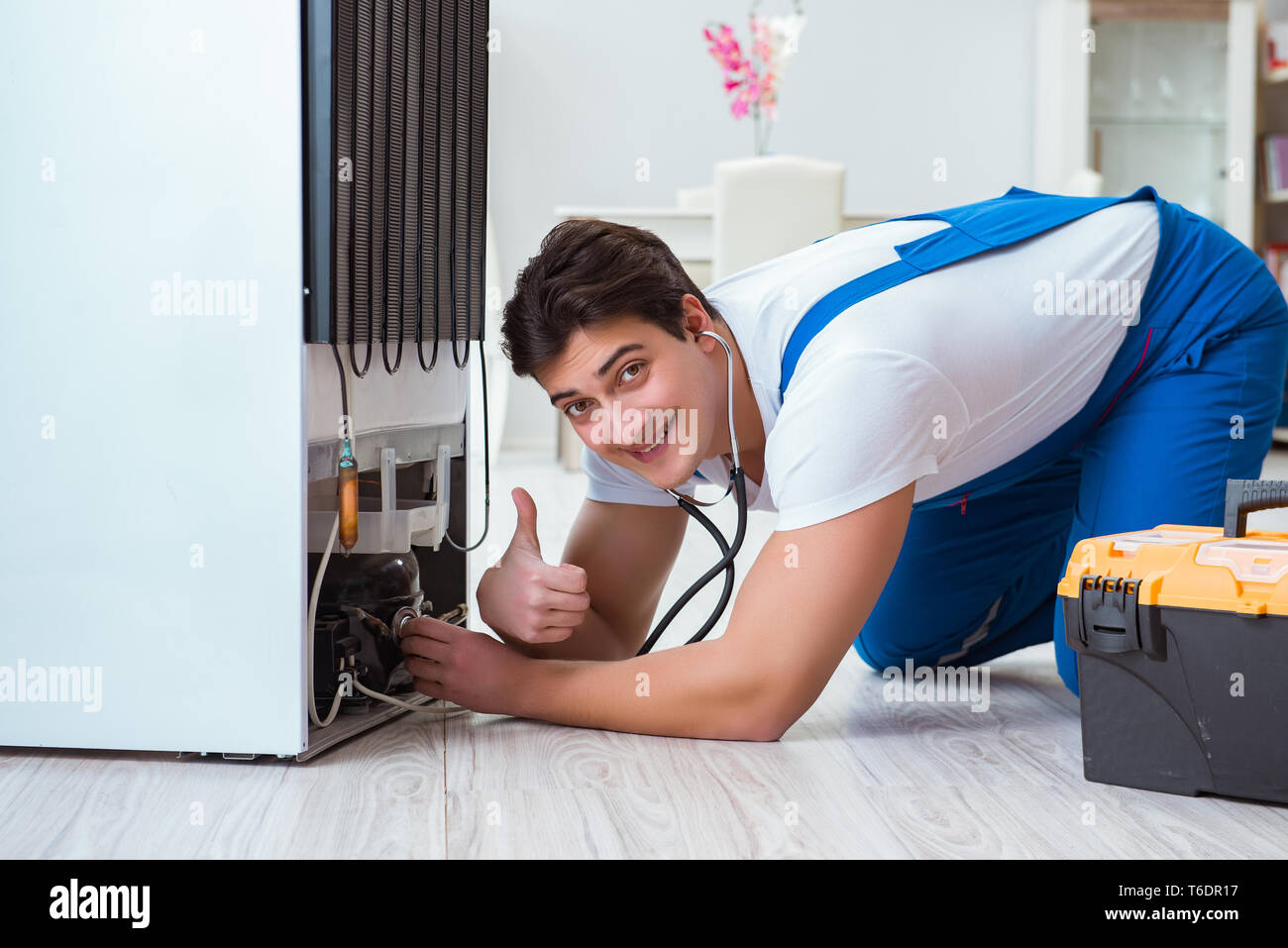 Handwerker Auftragnehmer Instandsetzung Kühlschrank im DIY-Konzept Stockfoto