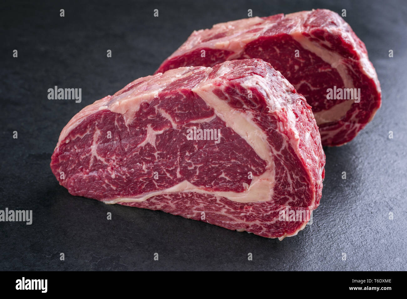 Zwei Rohstoffe chemische Kobe Entrecote Steaks als Close-up auf einer Schiefertafel im Alter von Stockfoto