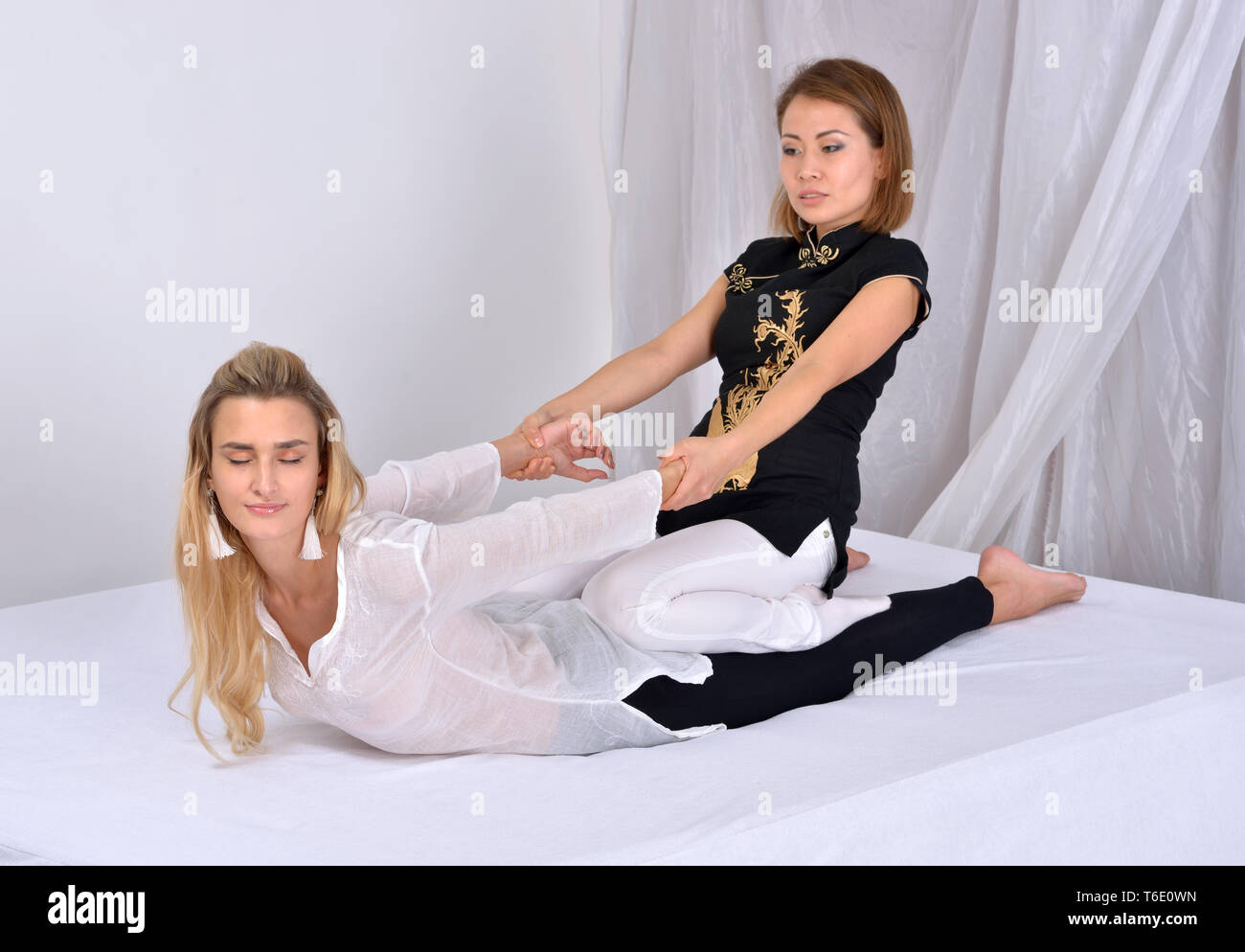 Thai Massage. Massage Therapeuten arbeiten mit Frau Stockfoto