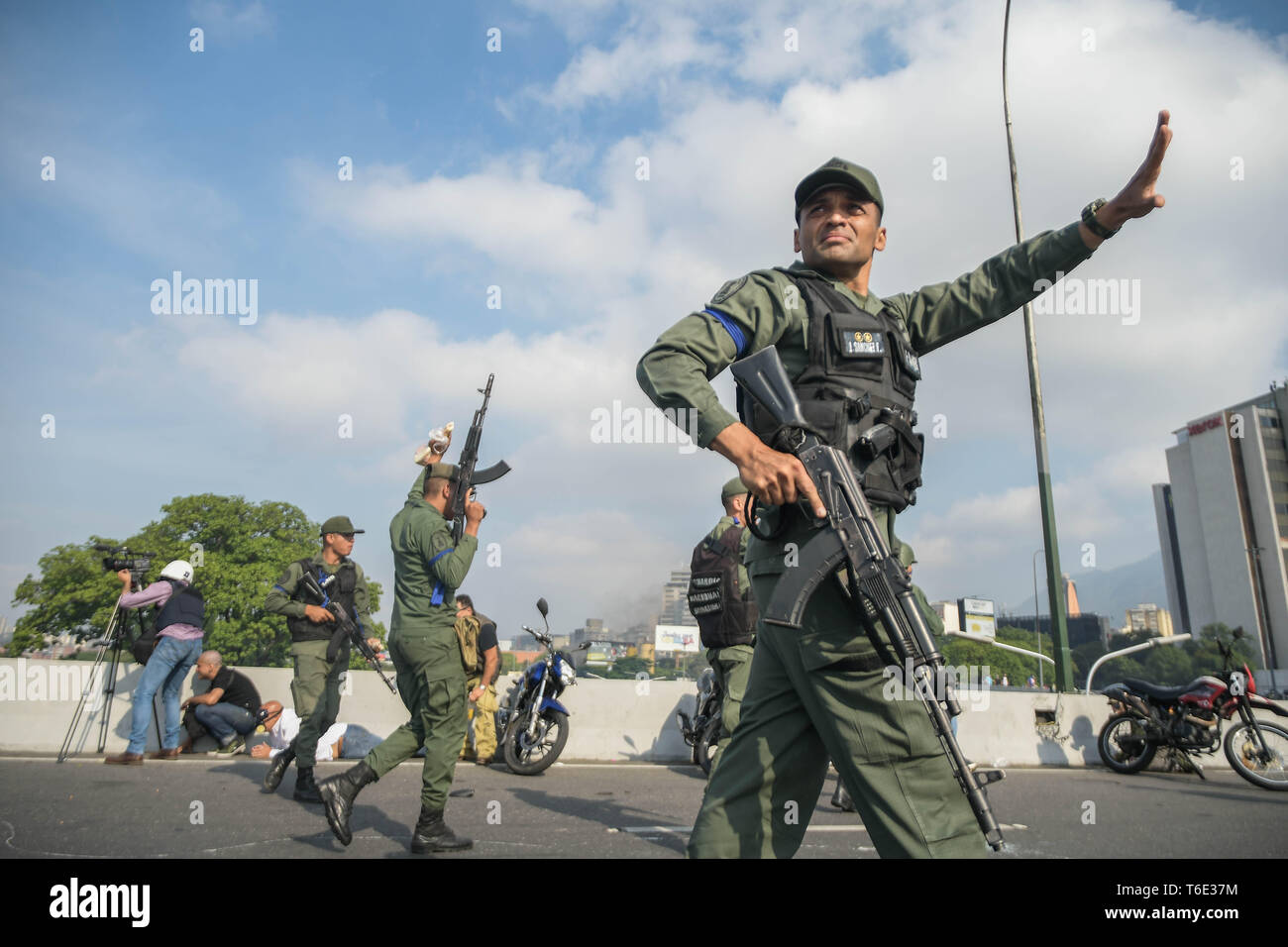 Die Regierung Soldaten, die den Militärputsch gesehen die Bewachung der Straße verbunden. Venezolanischen Militärs, die Unterstützung der venezolanischen Opposition leader Juan Guaido sind auf die Strasse mit ihren Waffen zusammen mit der Regierung die Demonstranten in einem Militärputsch gegen die sozialistische Regierung unter der Führung von Präsident Nicolas Maduro. Stockfoto