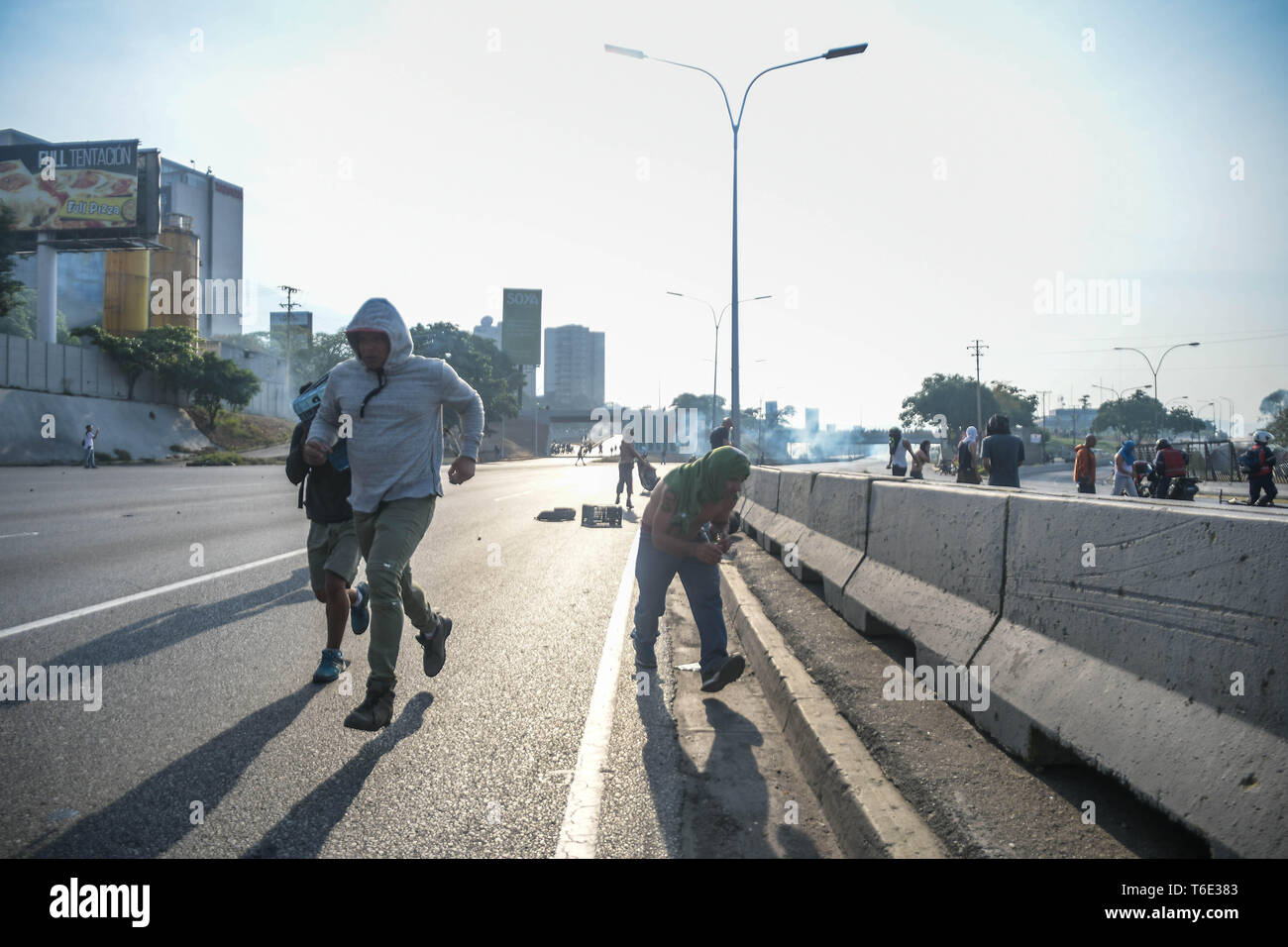 Die Regierung die Demonstranten auf der Straße während der militärputsch gesehen. Venezolanischen Militärs, die Unterstützung der venezolanischen Opposition leader Juan Guaido sind auf die Strasse mit ihren Waffen zusammen mit der Regierung die Demonstranten in einem Militärputsch gegen die sozialistische Regierung unter der Führung von Präsident Nicolas Maduro. Stockfoto