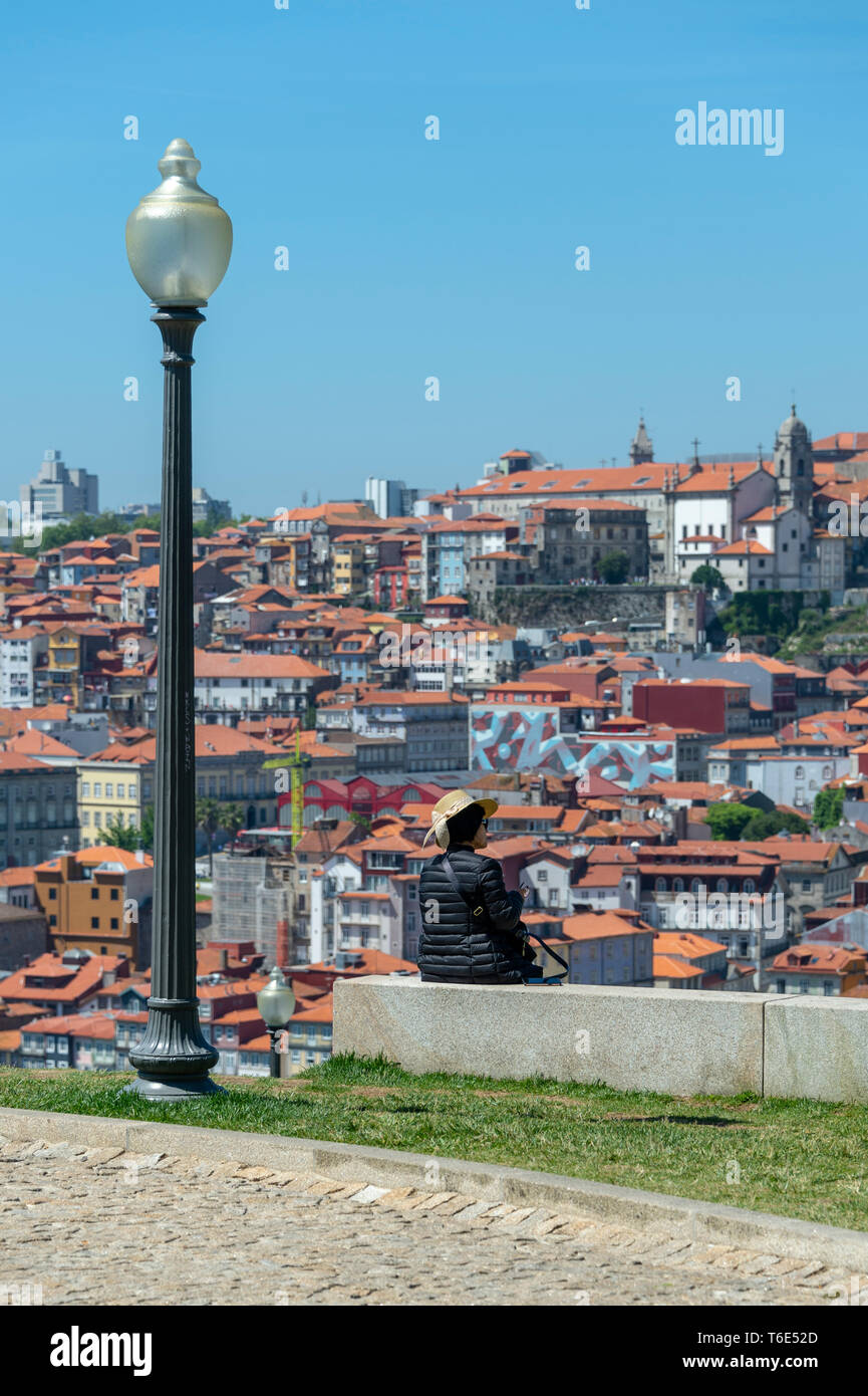 Panoramablick über Porto in Portugal, Frau Touristen sitzen auf einer Mauer die Aussicht genossen. Stockfoto