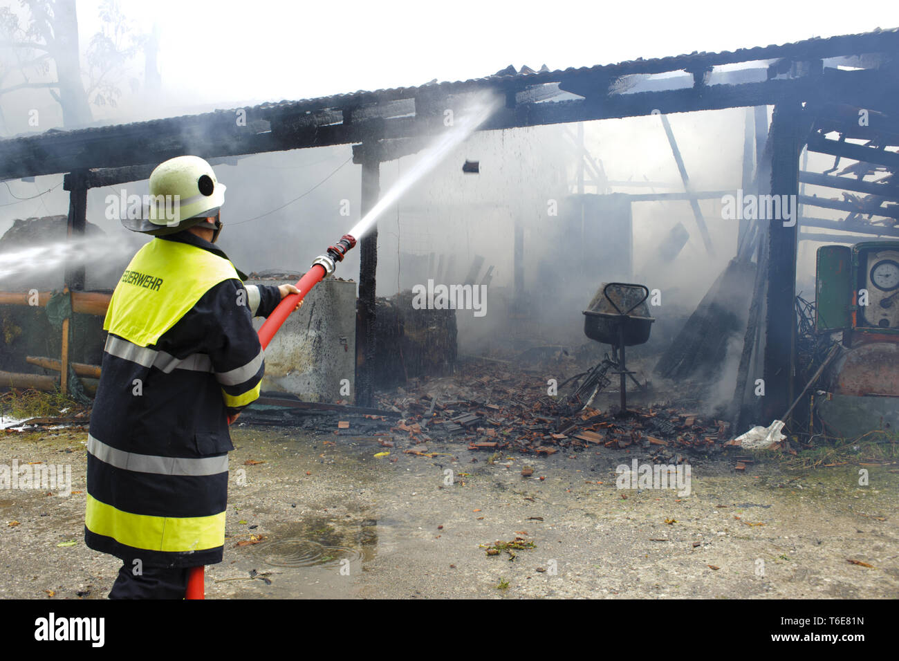 Feuerwehrmann im Einsatz bei brennendem Bauernhaus in Deutschland Stockfoto