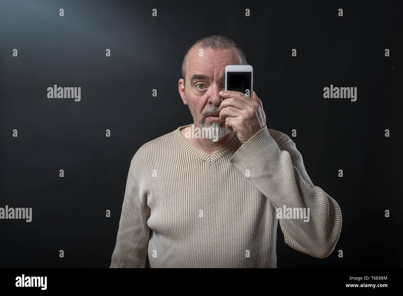 Der alte Mann versteht sein Smartphone nicht Stockfoto