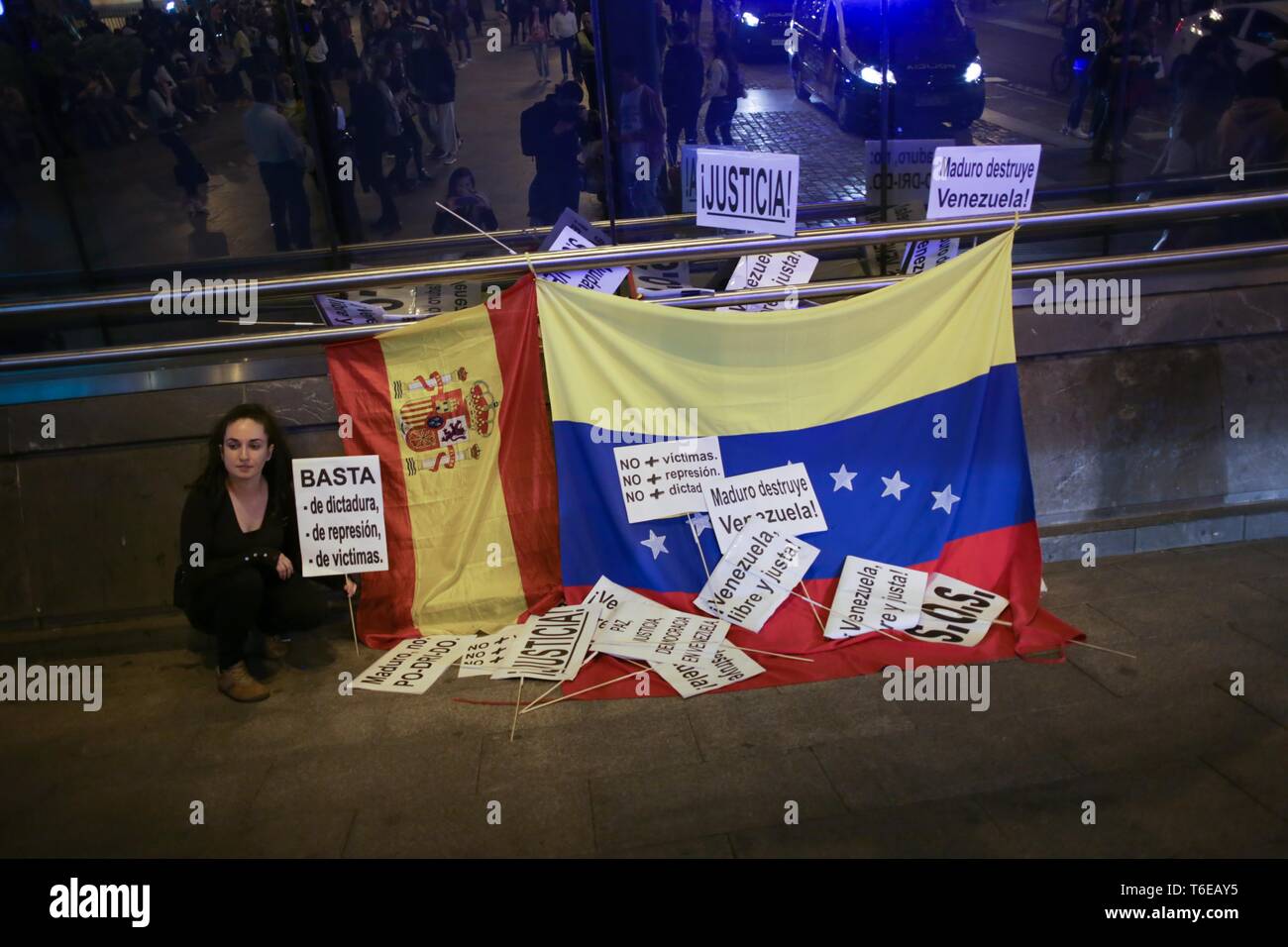 Eine Frau mit Plakaten neben venezolanischen Fahnen während der Vorführung gesehen. Hunderte von Menschen in Puerta del Sol in Madrid in einer Demonstration Freiheit erfasst, für die Freiheit von Venezuela gegen die Diktatur. Stockfoto