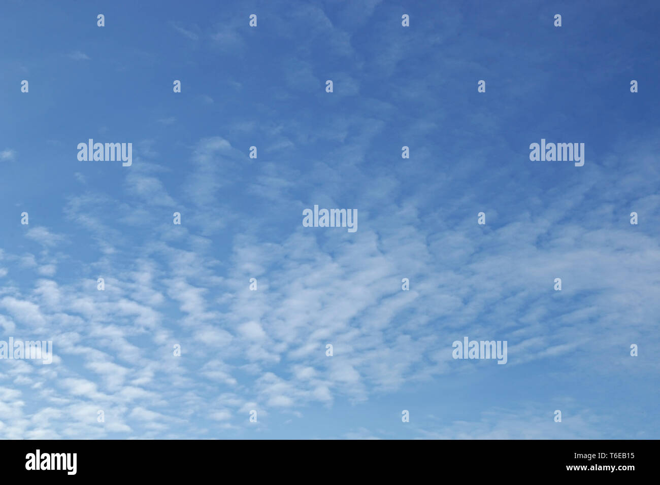 Blauer Himmelshintergrund mit winzigen Wolken Stockfoto