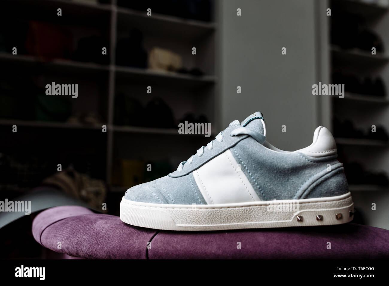 Ein paar modische Blue suede Sneakers auf eine weiße Sohle mit weißen Akzenten auf dem Hintergrund der Shop Stockfoto