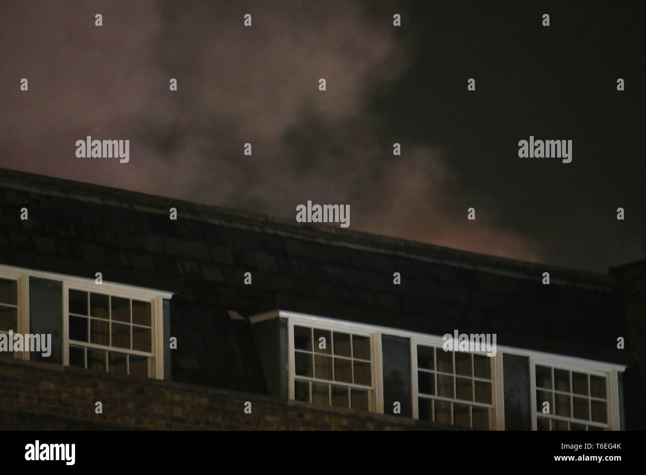 Rauch aufsteigt, aus einer großen Flamme an ein Spa, ein Hotel in West London verbunden. Rund 100 Feuerwehrleute sind anwesend, als sie das Feuer in das Gebäude zu bringen versuchen, in Richmond Hill. Stockfoto