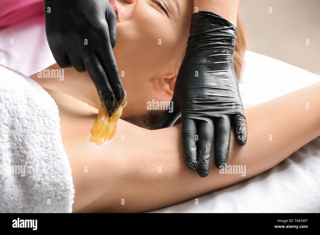 Frau, Haarentfernung mit zuckerpaste Einfügen in Salon Stockfoto
