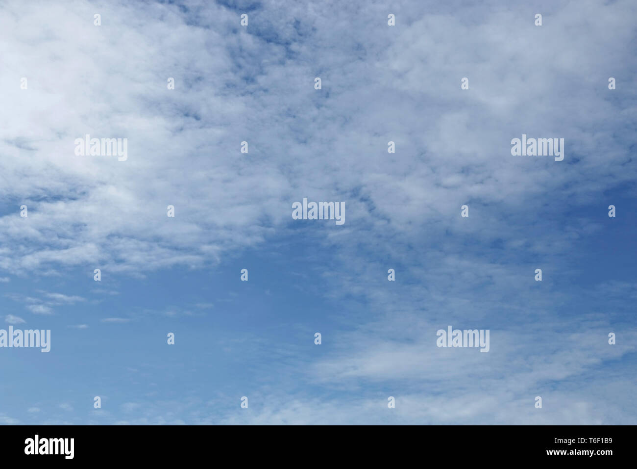 Blauer Himmelshintergrund mit winzigen Wolken Stockfoto