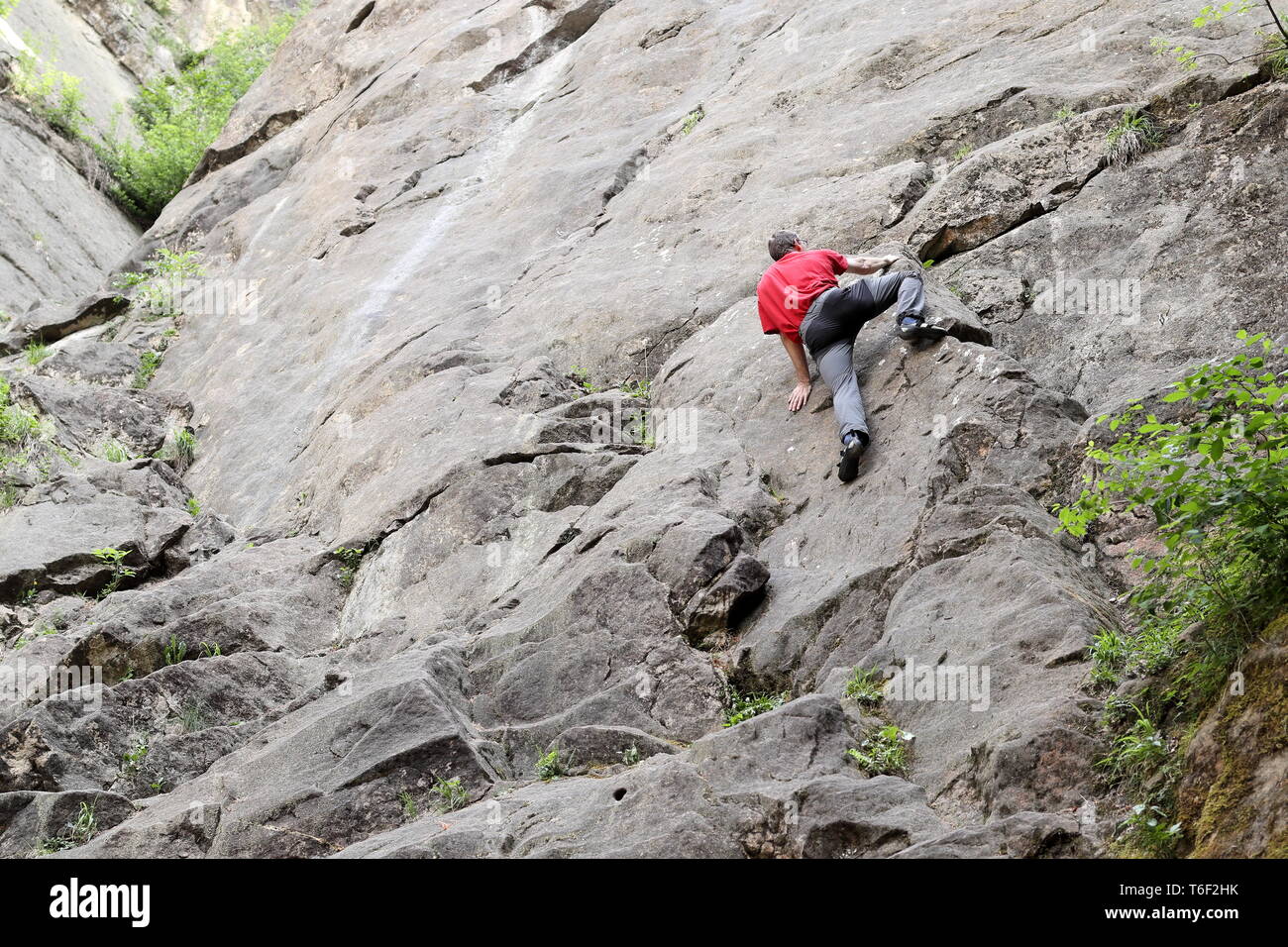 Klettern Mann auf einer Felswand Stockfoto