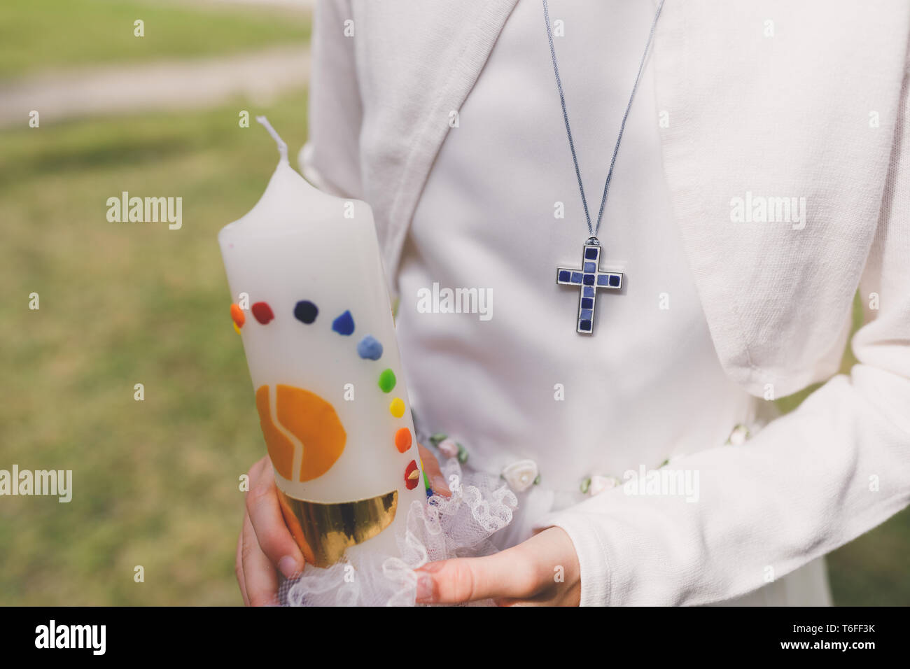 Junge Gemeinschaft kind Holding handgefertigte Kommunion Kerze in den Händen Stockfoto