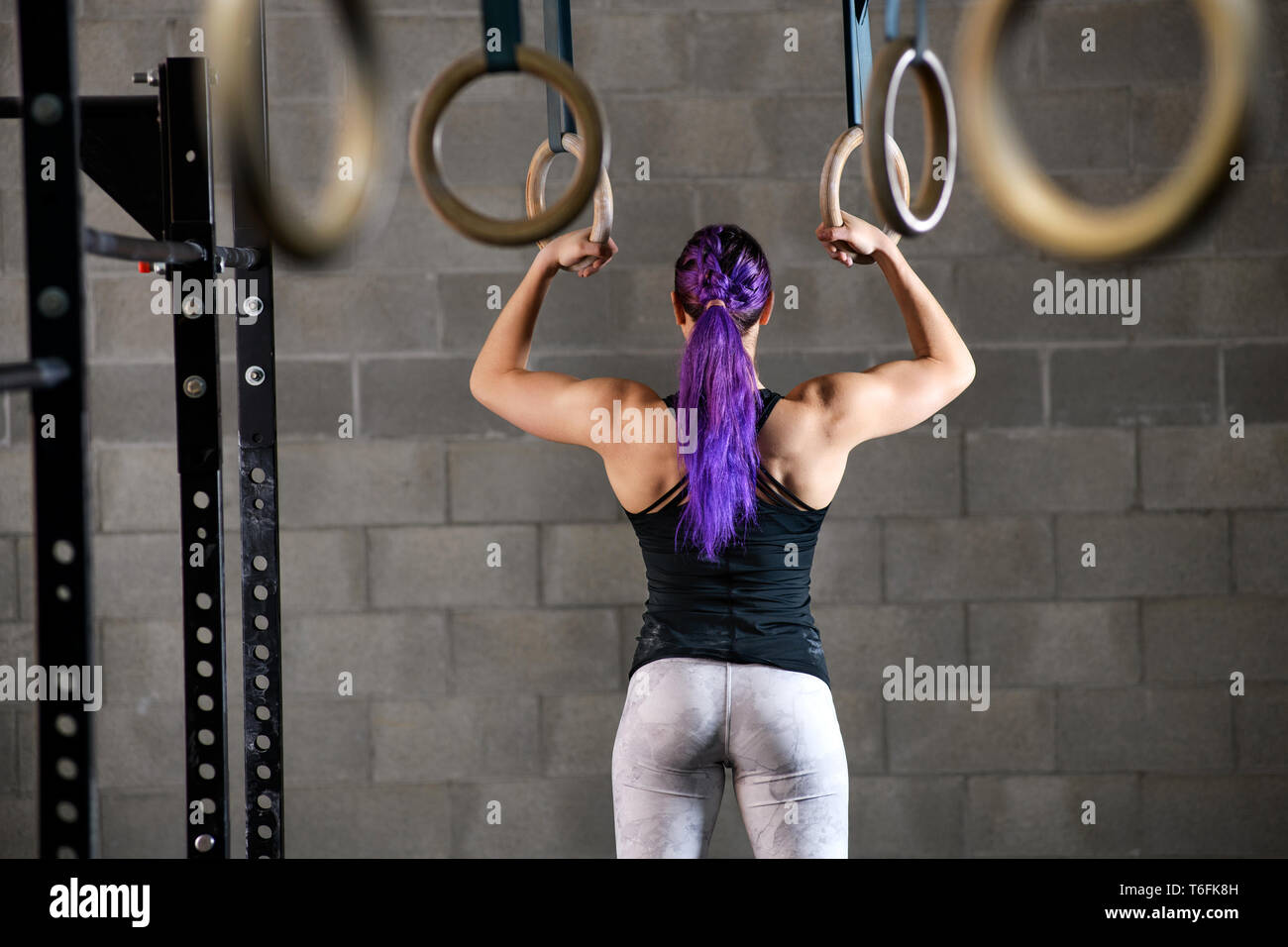 Muskulös passen starke Frau Athlet bereitet sich auf die Ringe in einem Fitnessstudio steht dabei mit dem Gesicht von der Kamera entfernt halten Sie in einem Gesundheits- und Fitnes zu arbeiten Stockfoto