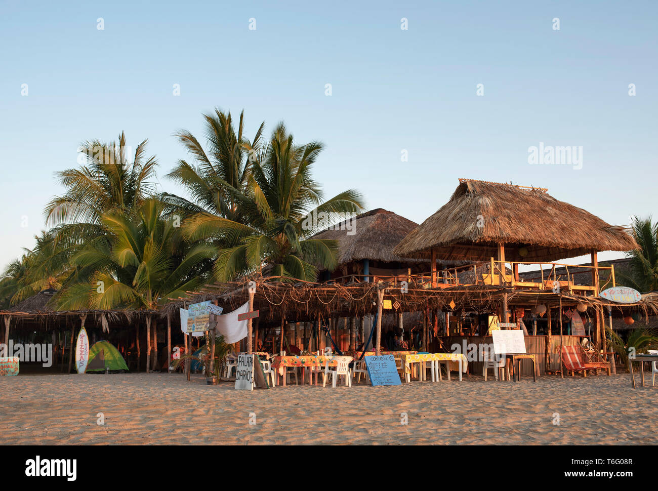 Einfache Strand Restaurants mit Strohdach und Plastikstühlen. Chacahua, Oaxaca, Mexiko. Apr 2019 Stockfoto