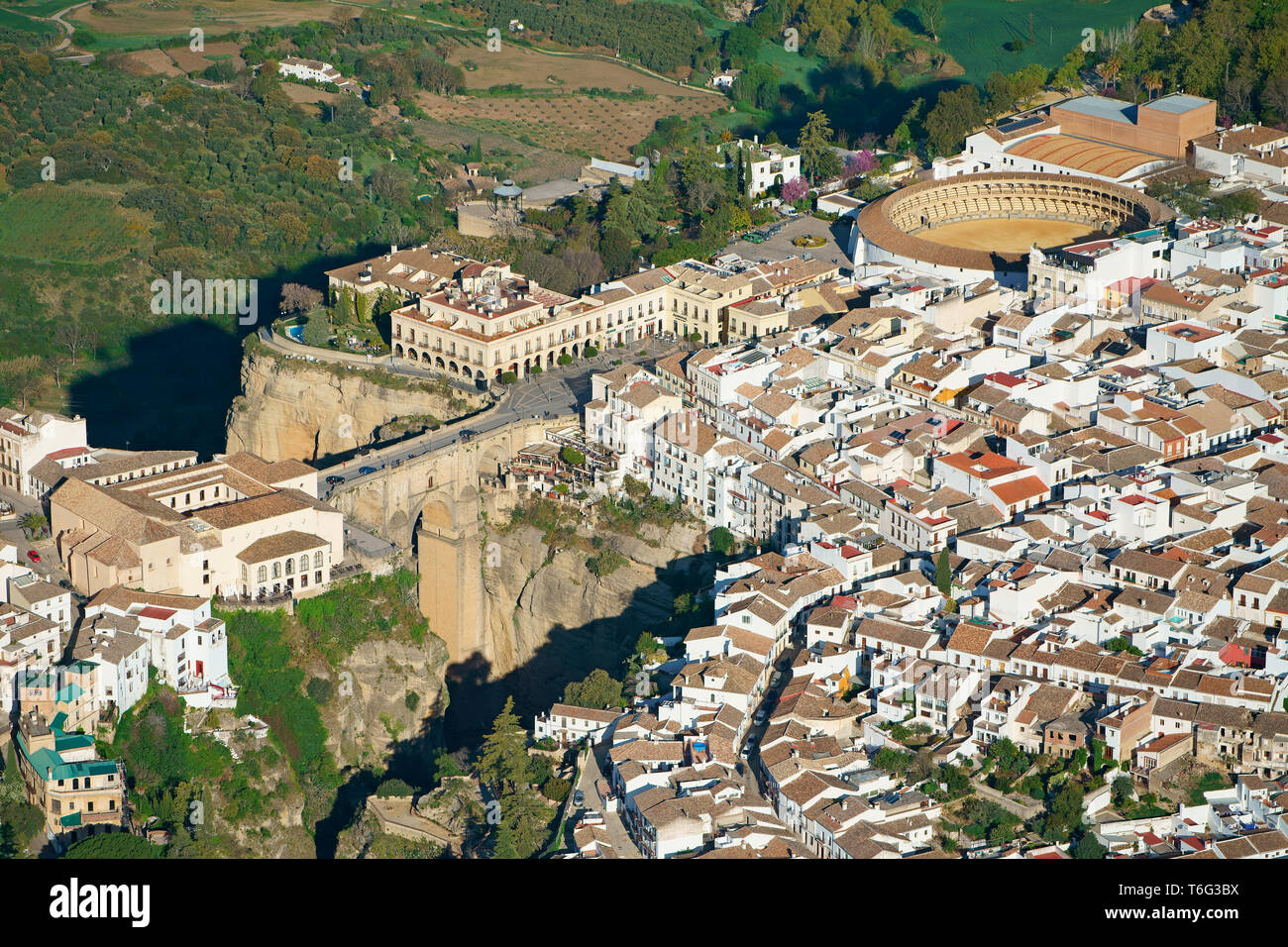 LUFTAUFNAHME. Historische, malerische Stadt, die durch einen tiefen Canyon halbiert wird. Ronda, Andalusien, Spanien. Stockfoto