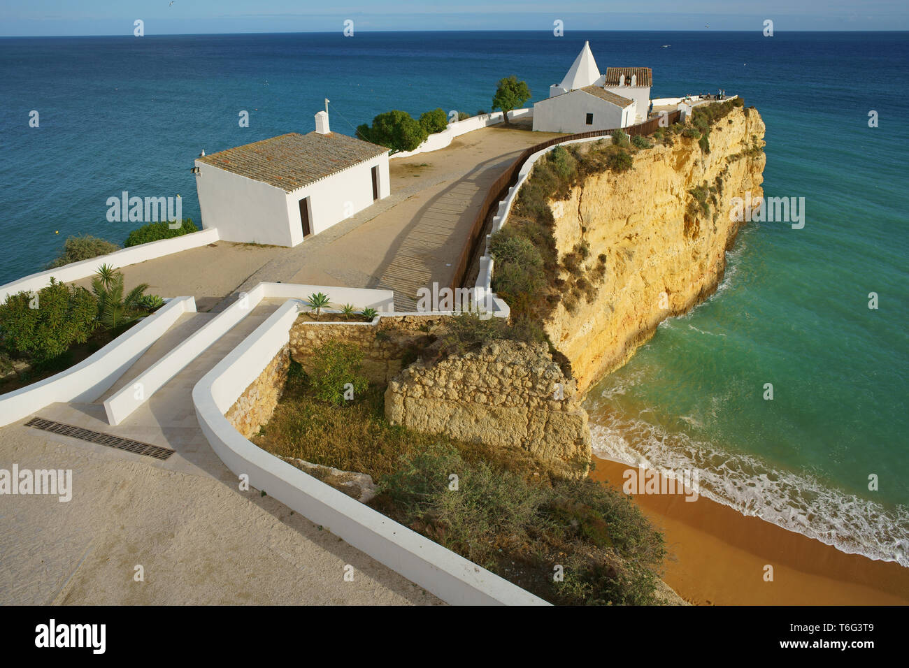 LUFTAUFNAHME von einem 6-Meter-Mast. Kleine Kapelle auf einer hohen und sehr schmalen Halbinsel. Festung Nossa Senhora da Rocha, Lagoa, Algarve, Portugal. Stockfoto