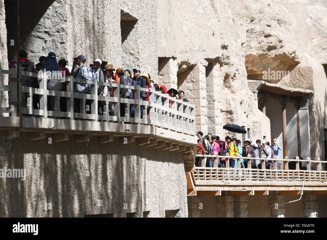 Dunhuang. Mai, 2019. Touristen besuchen die Mogao Grotten in Dunhuang, im Nordwesten der chinesischen Provinz Gansu am 1. Mai 2019, dem ersten Tag des 4-tägigen Mai Feiertag. Credit: Ventilator Peishen/Xinhua/Alamy leben Nachrichten Stockfoto