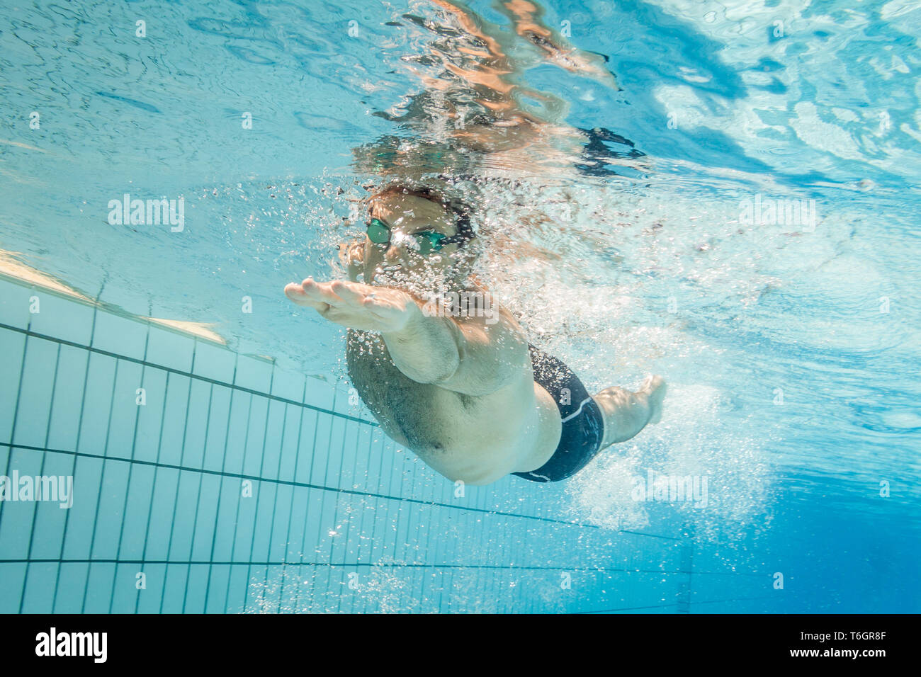 Männliche Schwimmer im Pool. Unterwasser Foto mit kopieren. Stockfoto