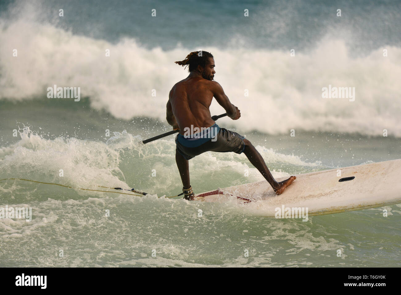 Paddel - Boarder weben ihren Weg durch die Brandung aus Dover Beach, Christchurch, Barbados. Stockfoto