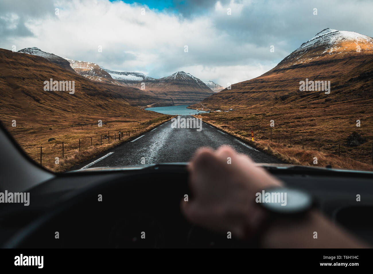 Aus der Perspektive des Fahrers in einem Auto auf der Fahrt durch das verschneite Täler auf den Färöern mit herrlichem Blick (Färöer Inseln) Stockfoto