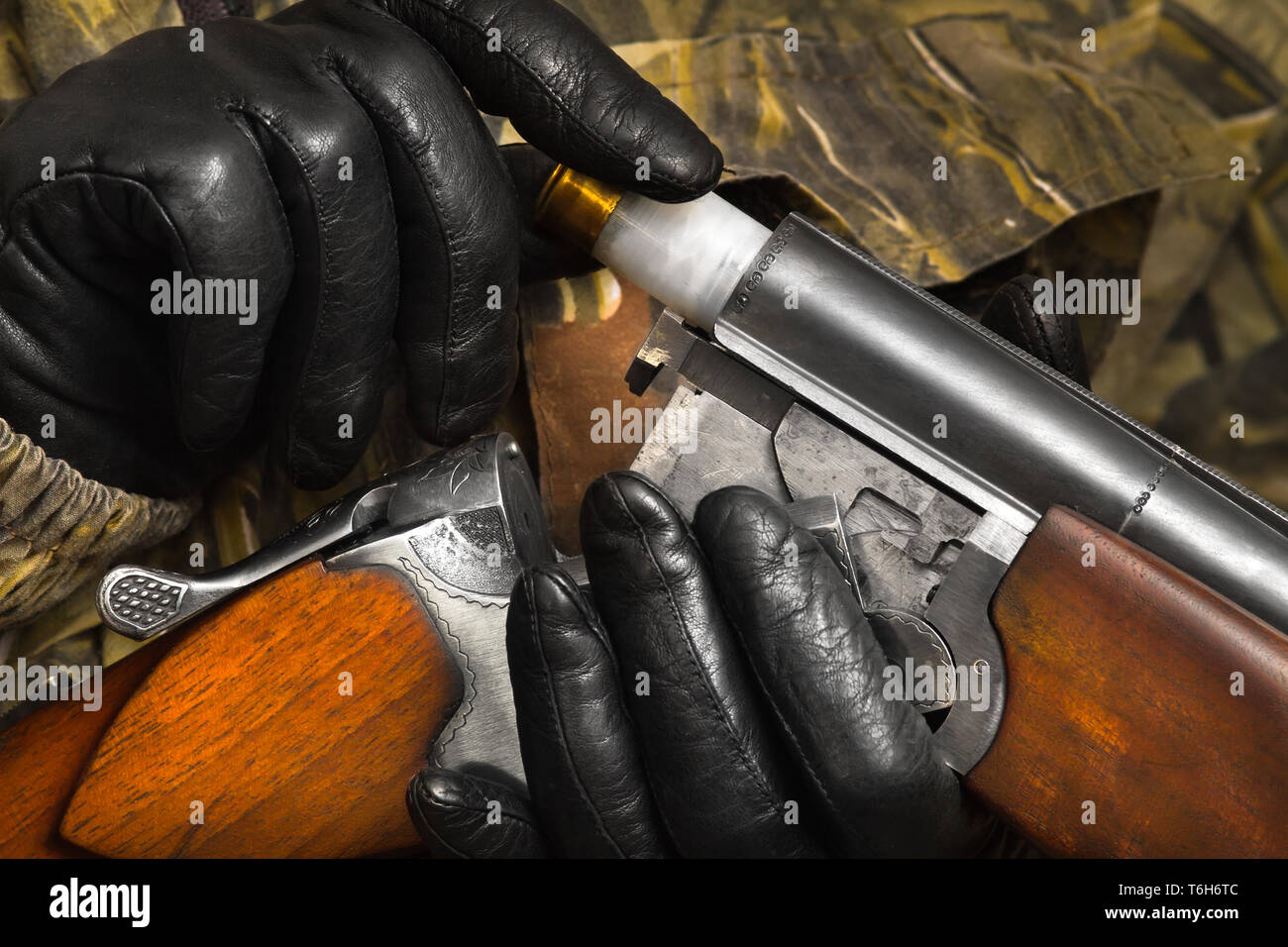 Hände der Shooter in Handschuhe Last eine doppelläufige Schrotflinte Stockfoto