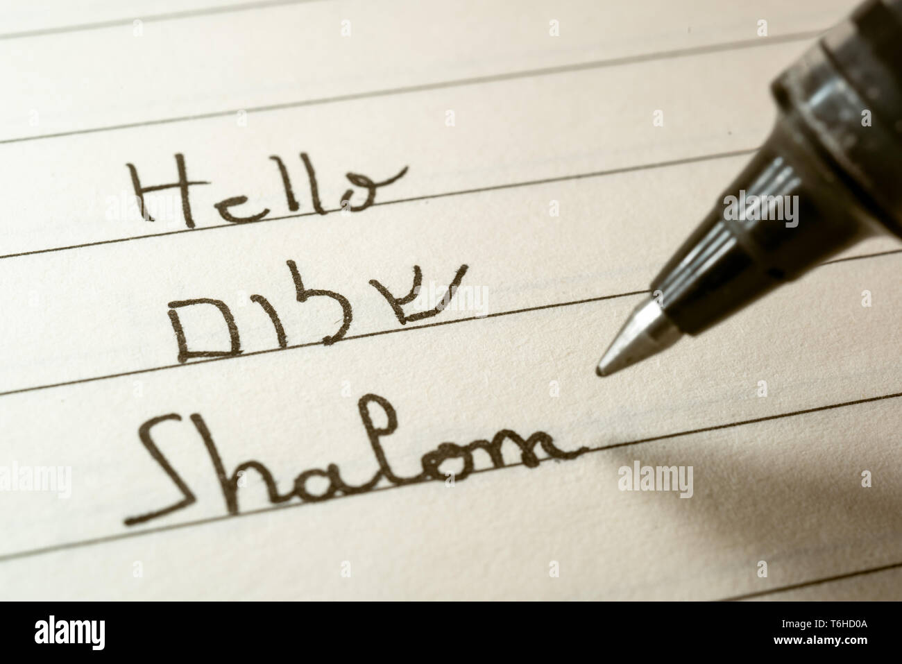 Anfänger Hebräische Sprache Lernende schreiben Hallo Shalom Wort im hebräischen Alphabet auf einem Notebook Nahaufnahme Stockfoto