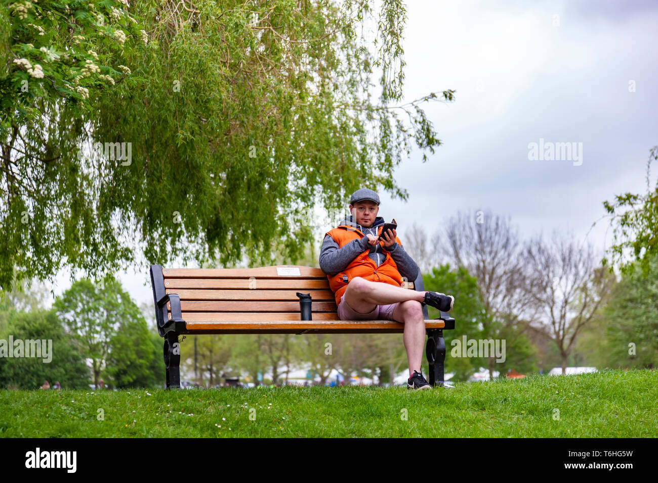 Mann saß auf einer Bank am Ufer des Flusses Avon in Stratford-upon-Avon, Warwickshire, West Midlands. Stockfoto