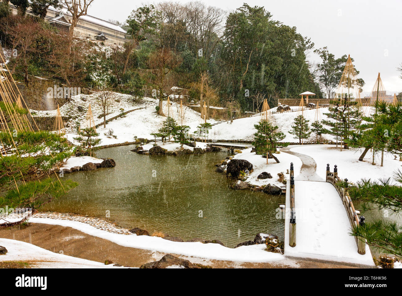 Gyokusen inmaru Japanischen Garten, die ursprünglich im Jahre 1634 erbaut. Garten, Teich, die Brücke und die erste Insel bei Schneefall. Burg Kanazawa, Japan. Stockfoto
