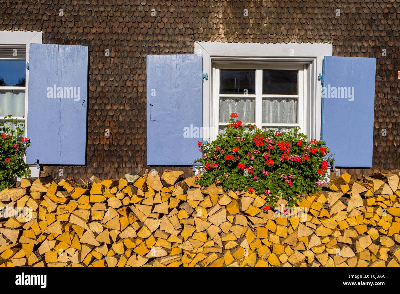 Schwarzwald Haus mit Walmdach und hölzerne Dachschindel Fassade, Gemeinde Bernau im Schwarzwald, Deutschland, Holzstapel unter lattice Windows Stockfoto