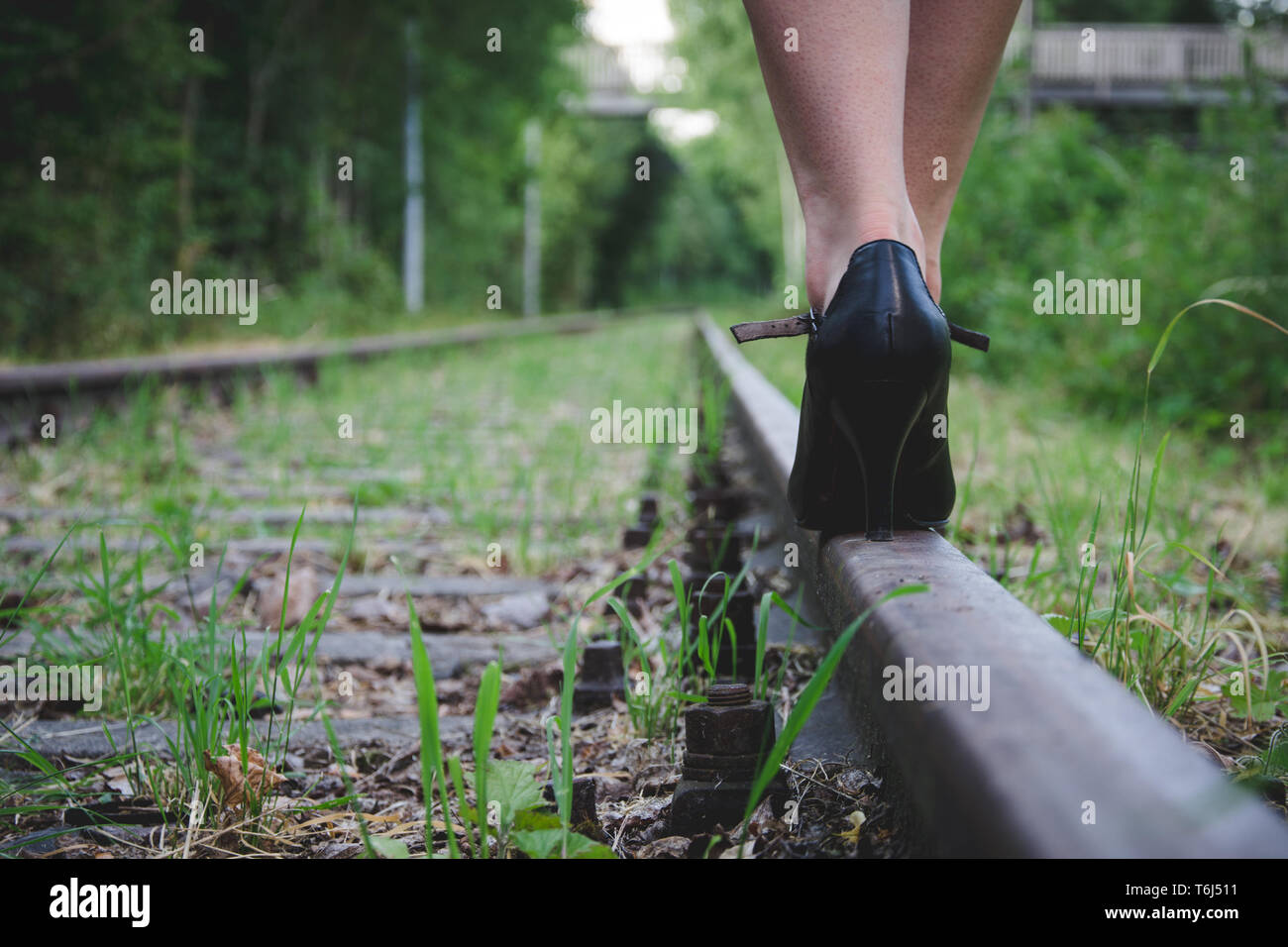 Frau mit High Heels auf einer Bahnstrecke Stockfoto