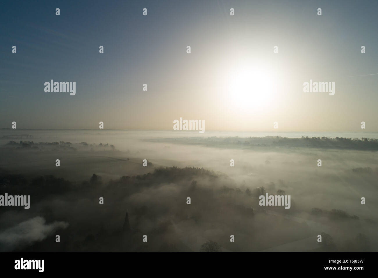 Dramatische Winter hohe Antenne Landschaft Blick auf die Sonne bricht über North Oxfordshire, England und seinen mächtigen Strahlen weg fahren Frost und Nebel Stockfoto