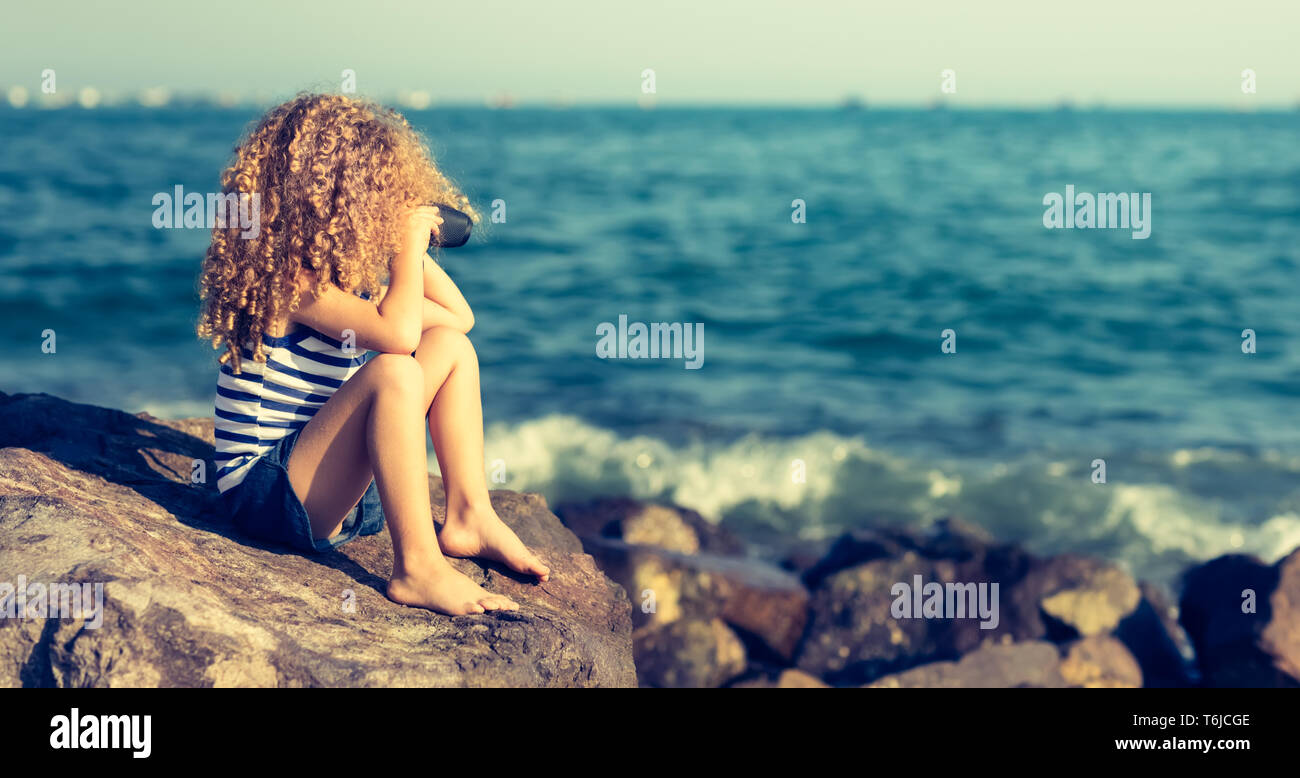 Kleines Mädchen auf der Suche weit weg mit dem Fernglas Stockfoto